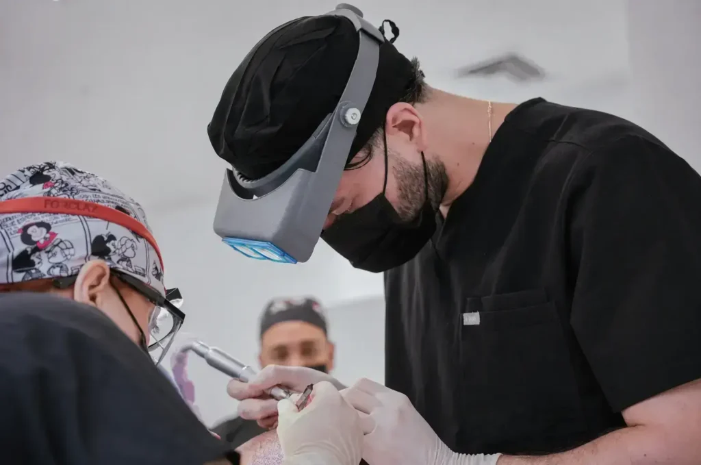 Surgeon with a headlight performing a hair transplant procedure